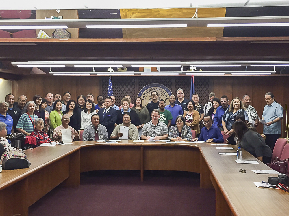 Attendees of the NDEAM Proclamation signing pose with Acting Governor Ray Tenorio.